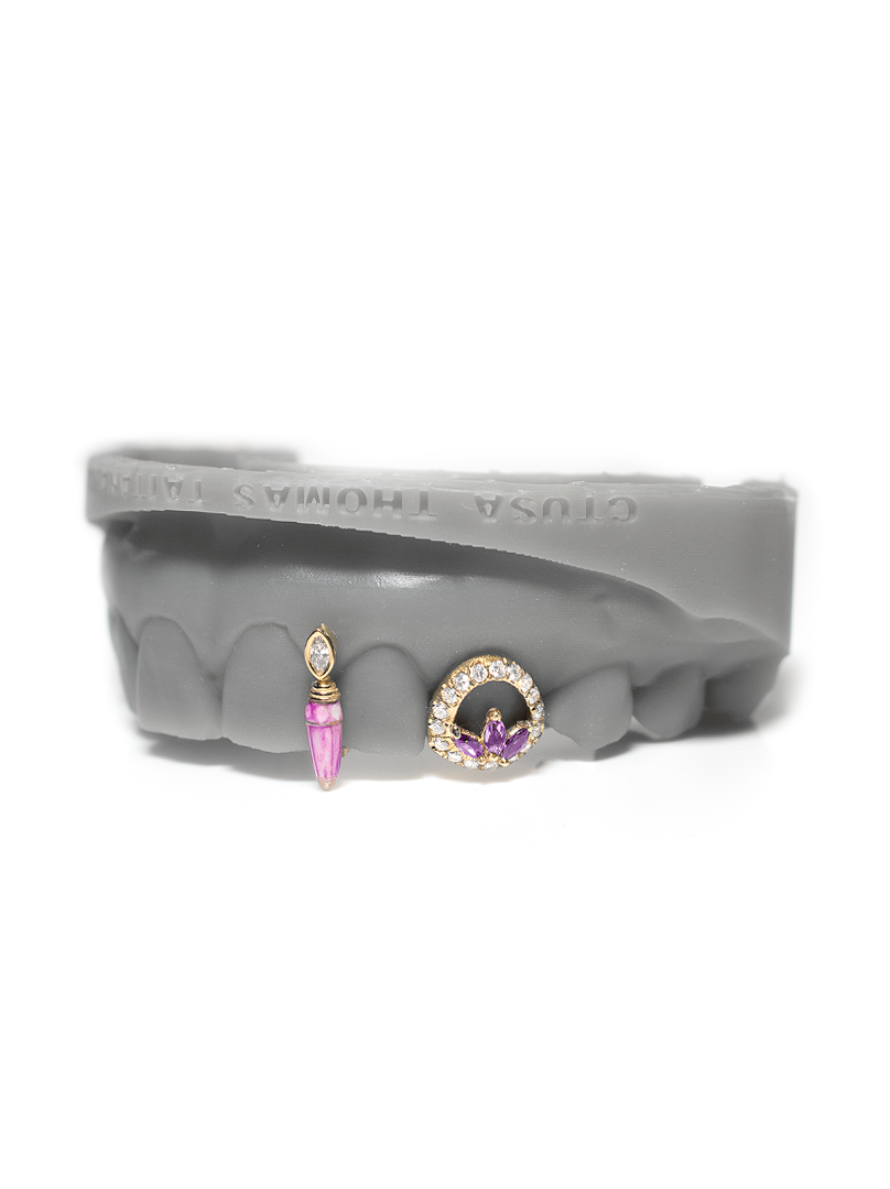 Solid gold grillz with a veined pink stone poison drop and a pave open diamond face with marquise cluster center
