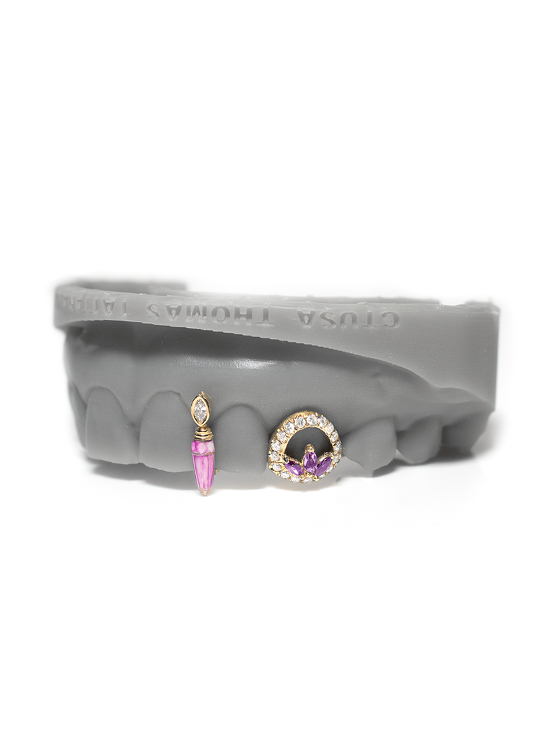 Solid gold grillz with a veined pink stone poison drop and a pave open diamond face with marquise cluster center