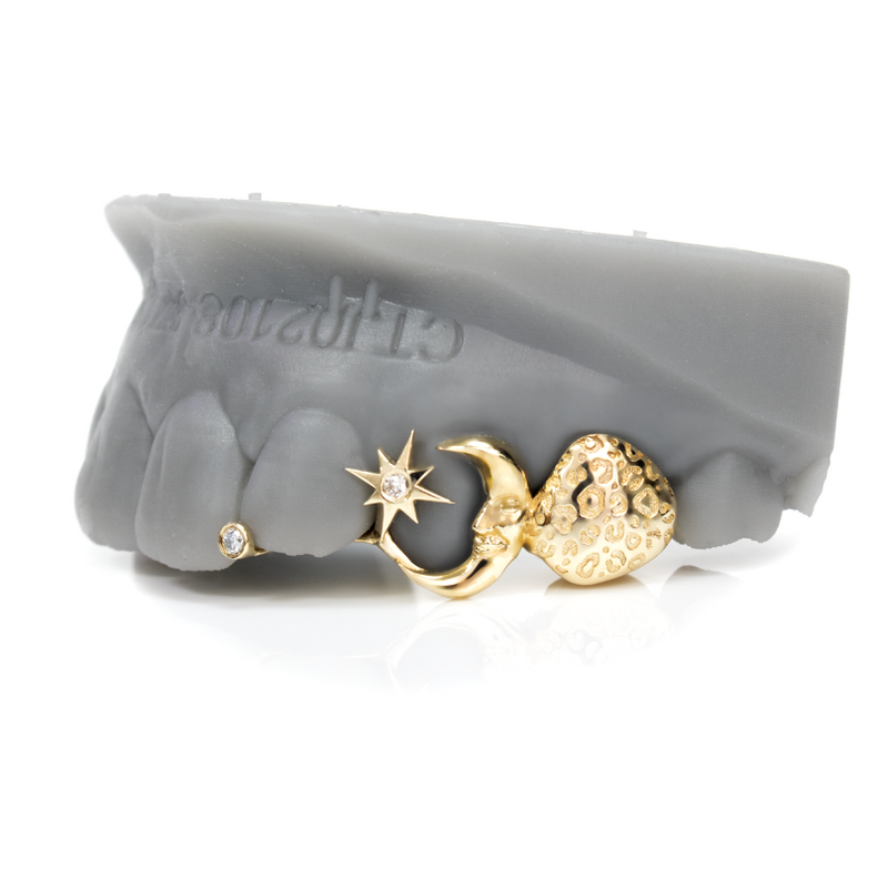 Solid gold grillz with stone-set star, crescent moon and textured nugget heart, plus a bezel-set diamond cap
