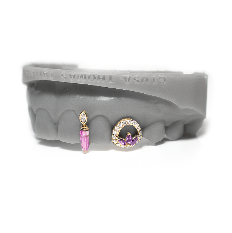 Solid gold grillz with a veined pink stone poison drop and a pave open diamond face with marquise cluster center